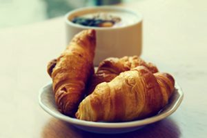 Tasty fresh breakfast with croissants on plate on wooden table. Tasty fresh breakfast with croissants on plate on wooden table.