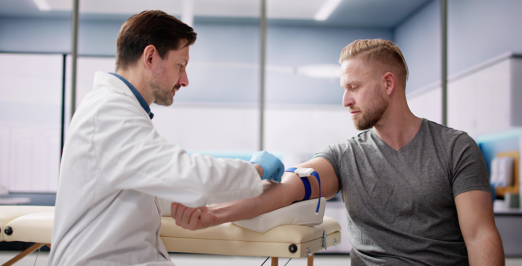 Medic luând sânge unui tânăr pentru analize