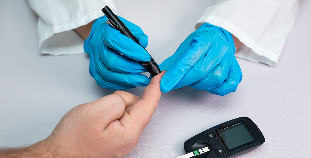 Medic verificând glicemia unui pacient